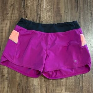Athleta Magenta record breaker shorts with Black Waistband and Peach Pockets